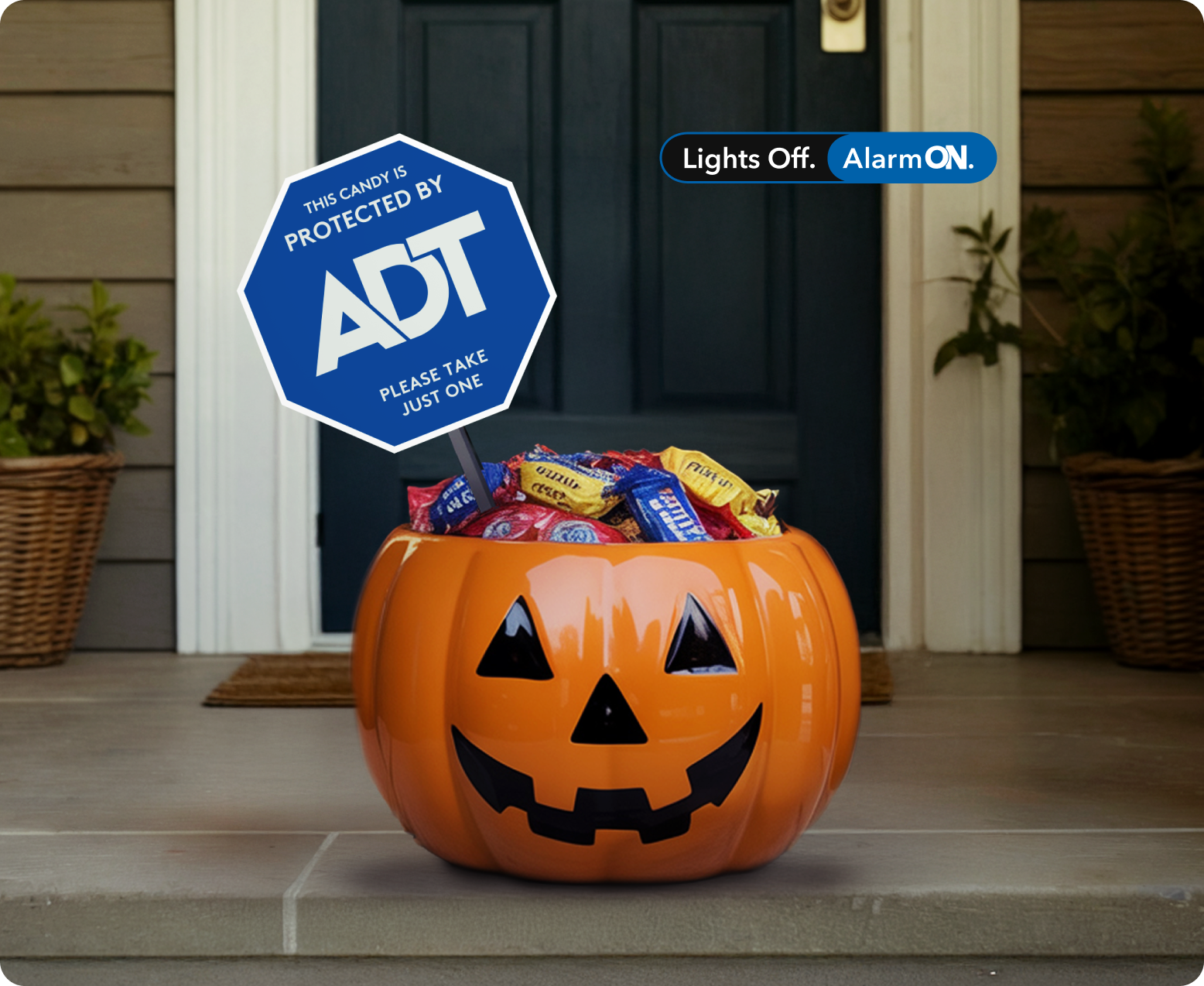 Halloween candy bucket on doorstep with special holiday ADT yard sign reading 
