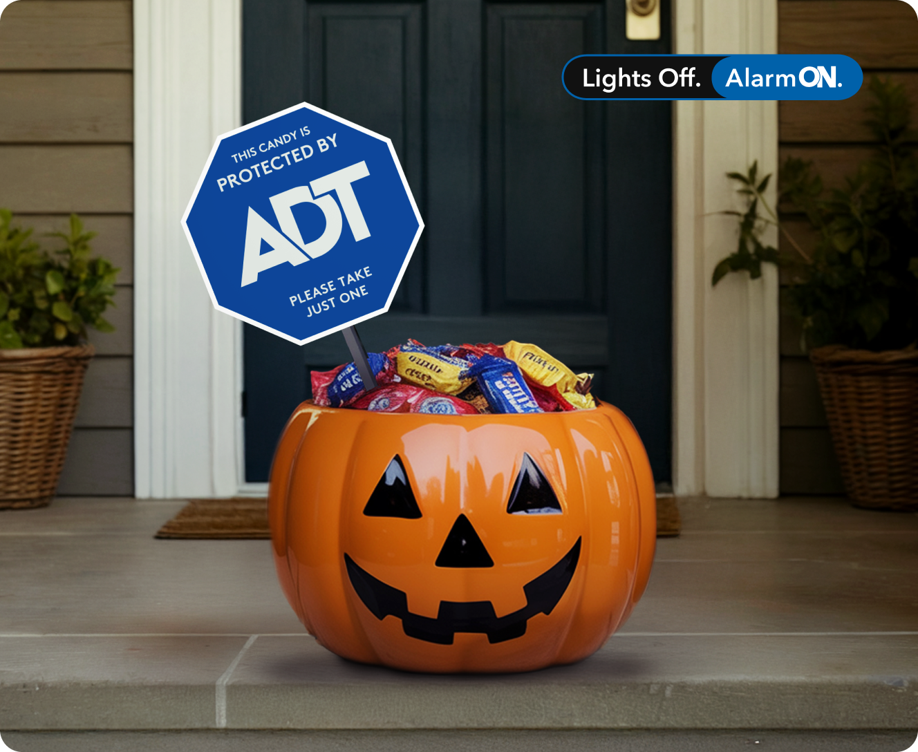 Halloween candy bucket on doorstep with special holiday ADT yard sign reading 